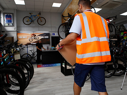 Postie delivering parcel to bike shop