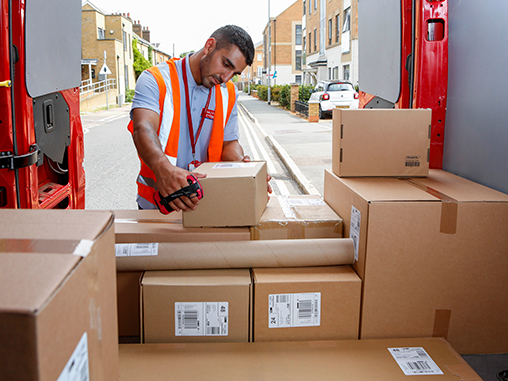 Postie arranging parcels in a van